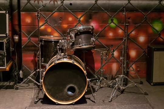A set of old beat-up dusty drums on a stage