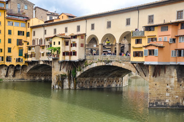 Fototapeta na wymiar Ponte Vecchio or Old Bridge is a medieval stone bridge over the Arno River, in Florence, Italy. It's noted for having shops on in. Photos taken right after the rain as the sun was coming out.
