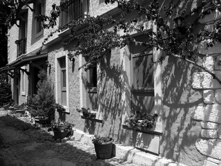 Alte Gasse mit Blumenschmuck und schönem Altbau im Sonnenschein  in der Altstadt von Alacati bei...