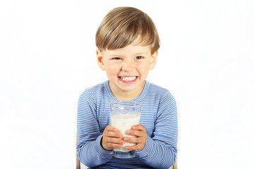 Ein dreijähriger Junge trinkt ein Glas Milch