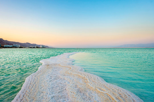 Israel, South District, Ein Bokek. Salt formations on the Dead Sea at sunset.