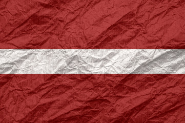 Latvia flag on old crumpled craft paper.