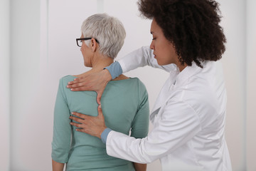 Woman having chiropractic back adjustment. Osteopathy, Physiotherapy, Injury rehabilitation concept