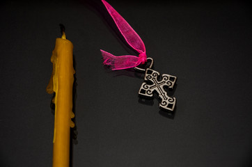 extinguished candle and cross on black background