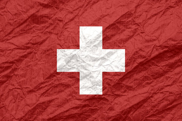 Switzerland flag on old crumpled craft paper.