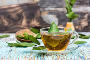 Fresh tea from bay leaf in a cup on a wooden rustic table
