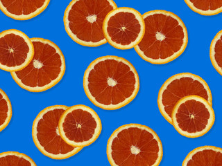 Creative pattern made of red oranges. top view of colorful fruit pattern of fresh red orange slices on blue colorful background. 