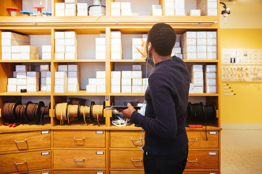 Young male owner checking boxes in rack at furniture store