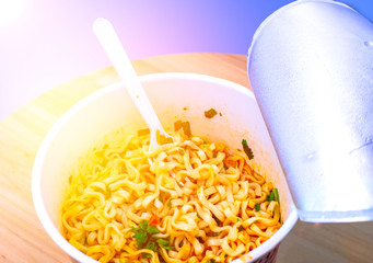 Instant noodle. noodle soup in a cup, view from above. Instant noodles are sold in a precooked and dried noodle block, with flavoring powder and,or seasoning oil.