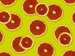 Creative pattern made of red oranges. top view of colorful fruit pattern of fresh red orange slices on yellow colorful background. 