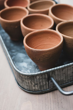 High angle close up of terracotta plant pots on metal tray.
