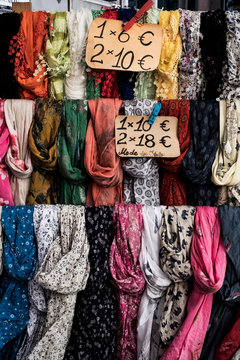 Close up of a large selection of colourful scarves at a market stall.