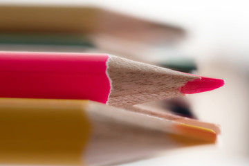 Obraz premium Sharpened colored pencils close-up. Ready-to-use pencils in a stack. Pink pencil in sharpness.