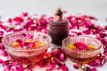 Obraz na płótnie Canvas Rose water face pack isolated with essential oil of rose well mixed with honey in a glass bowl and entire raw ingredients present on the surface used for skin brightening.