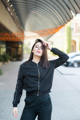Obraz premium Beautiful smiling young woman wearing black jacket