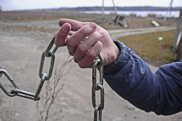 man holds a metal chain