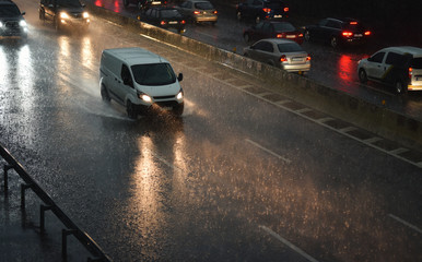Fototapeta na wymiar delivery van speeding by highway in rainy night
