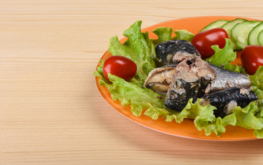 Pieces of sardine iwashi on lettuce leaves with red tomatoes.