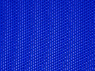 Close-up of blue fabric plastic textile lattice or grid texture. Horizontal and vertical crossover lines. A lattice work of interwoven blue plastic textile textured strips forms a pattern background