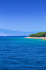 Fototapeta na wymiar The coast between the islands of Krk and Cres in the Adriatic Sea in Croatia. Wonderful romantic summertime seascape with crystal clear azure sea and emerald green coastline slopes.