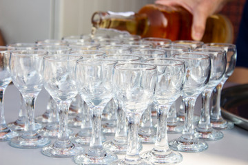 rows of glasses of wine and someone serving different port wines