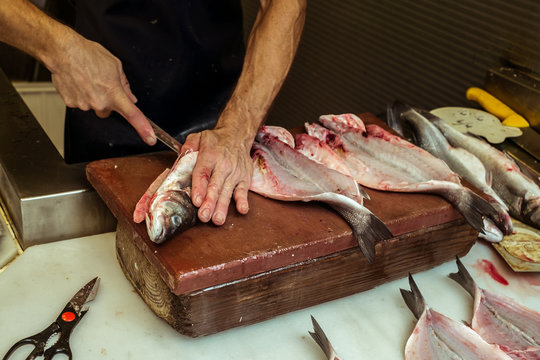 a man eviscerating  fresh fish