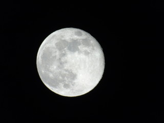 Genova, Italy - 03/22/2019: An amazing photography of the full moon over the city of Genova by night with a great clear sky in background and some stars