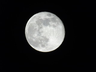 Genova, Italy - 03/22/2019: An amazing photography of the full moon over the city of Genova by night with a great clear sky in background and some stars