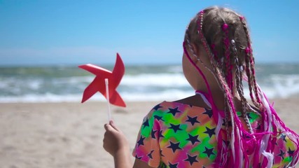 A girl holds a toy windmill in her hands