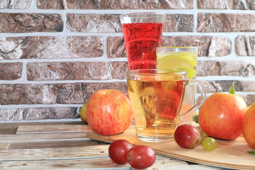 Grape and apple juice, fruit on a wooden background. Cool drinks, a mix of different varieties of...