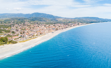 Fototapeta na wymiar Città costiera calabrese di Marina di Gioiosa Ionica in Calabria. Vista aerea sulle spiagge che si affacciano nel mare Mediterraneo, meta turistica in Estate. Il suo lungomare e le case in affitto.