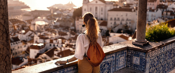 Female tourist looking at old town from balcony - obrazy, fototapety, plakaty