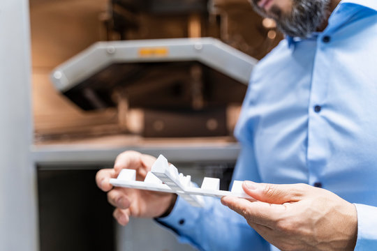 Close-up of man holding workpiece at d printer