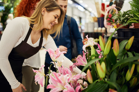 Shop assistant advising couple in flower shop