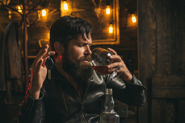 Fototapeta na wymiar Man with beard holds glass brandy. Macho drinking. Confident man with car keys in his hand.