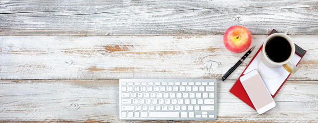 Overhead view of a functional desktop with various office equipment and snack foods