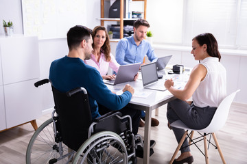 Disabled Manager Sitting With His Colleagues