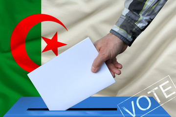 Male hand puts down a white sheet of paper with a mark as a symbol of a ballot paper against the...