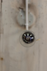 Vintage light bulb hanging on white background.