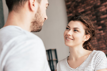 joyful attractive girl looking at boyfriend with smile