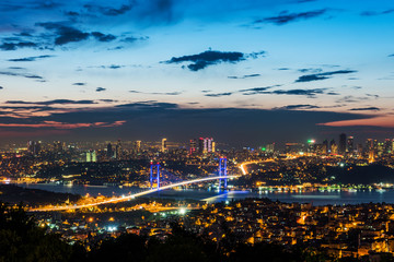 Naklejka premium Istanbul Bosphorus Bridge at sunset. 15th July Martyrs Bridge. Night view from Camlica Hill. Istanbul, Turkey..
