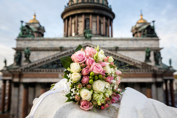 Buds of pink and white roses in a wedding bouquet on the background of the cathedral