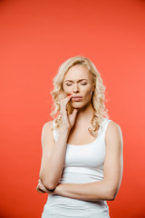 attractive woman with closed eyes having toothache on red