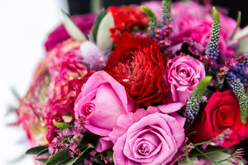 Exquisite bridal bouquet of red and pink roses in combination with wildflowers