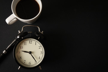 Coffee Time Concept: Office leather desk table with coffee cup and alarm clock. Top view with copy space