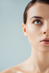 cropped view of young naked beautiful woman with shiny makeup isolated on grey