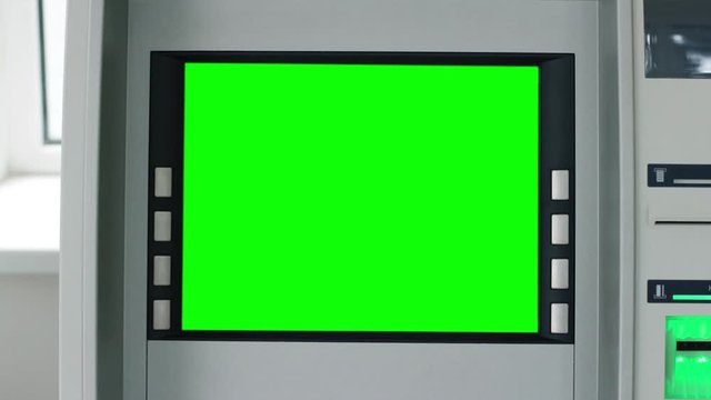 Close up view of ATM machine with green screen and blinking green signal. Cash machine or money dispenser machine with green screen. Technologies, money and cash, chroma key screen. Close up view