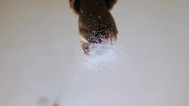 Bottom view of male hand scaterring sugar on glass table. Close-up of drug addict preparing sugar path. Sugar addiction.