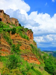 Fototapeta na wymiar Stone cliff houses perched on a cliff in a hill town of Tuscany Italy.