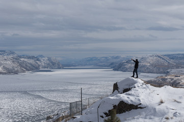 Fototapeta premium man pointing frozen lake